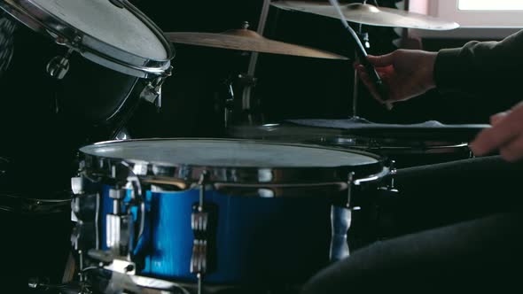 Drummer Man Sits Down to Play the Drum Set