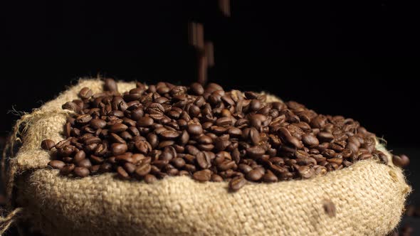 Roasted Coffee Beans Falling On Pile Of Seed In Sack Bag