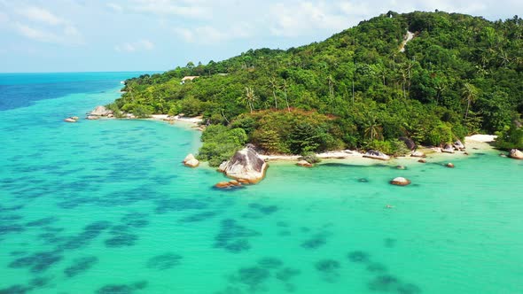 Wide angle fly over tourism shot of a white sandy paradise beach and aqua turquoise water background