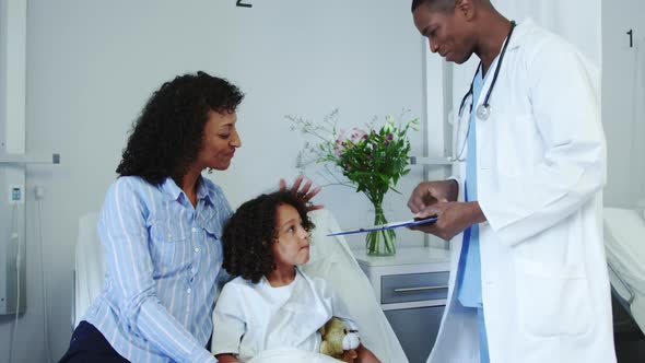 Front view of African american male doctor doing routing check-up in the ward at hospital 