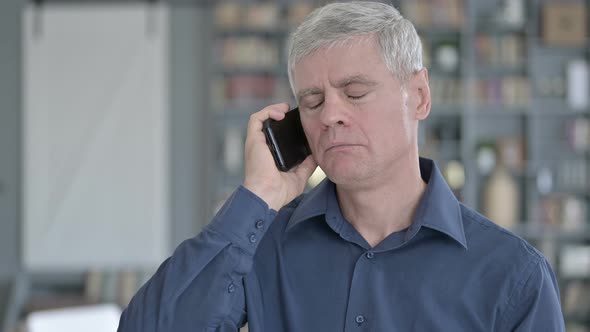 Portrait of Serious Middle Aged Man Talking on Smartphone