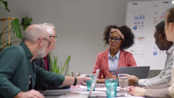 Afro-American Business Lady Speaking with Team at Corporate Meeting