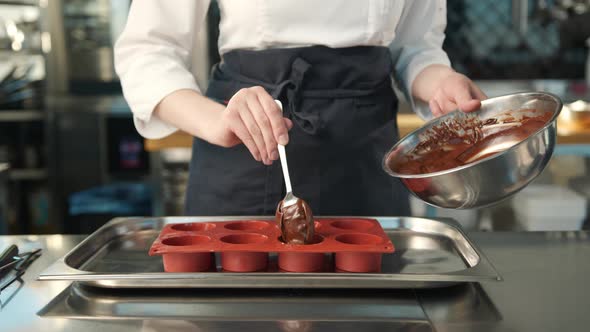 Close-up of chocolate being placed in a baking dish. Brownie preparation.