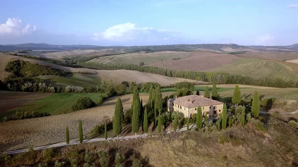 Traditional Italian villa on top of a hill in the Tuscan countryside, Aerial drone lift reveal shot