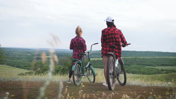 Young Mother and Daughter with Bikes on Mountain.