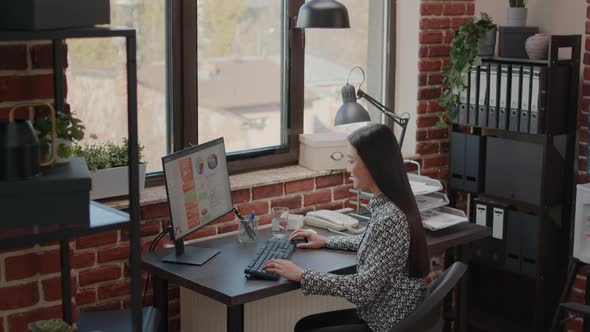 Business Woman Working on Annual Data Charts in Office