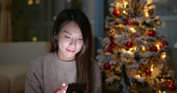 Woman use of cellphone at Christmas decoration