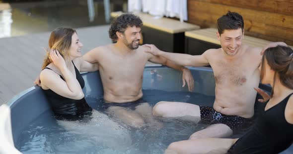 Friends Having Fun Bathing at Spa Outdoors