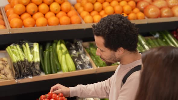 Mixed Race Man Taking Tomatoes in Supermarket