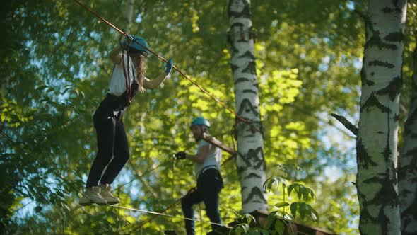 Woman and Man in Full Insurance Crossing the Rope From One Tree To Another - an Entertainment