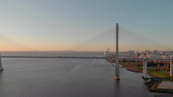 Vasco da Gama Bridge and Lisbon coast at sunrise, Portugal. Aerial approach