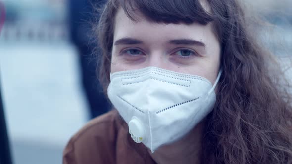 Closeup of a Woman in a Protective Mask Who Looks Directly Into the Camera Evening Picture