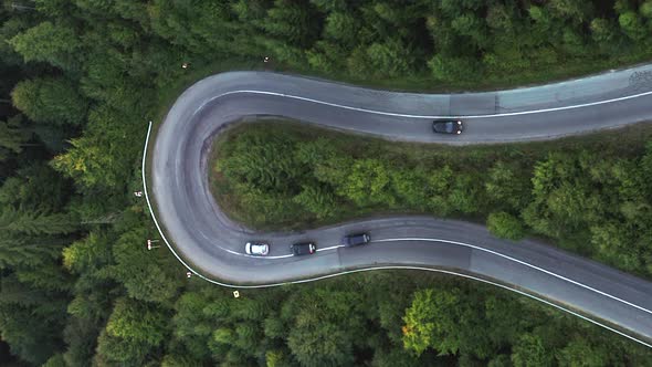 Vertical format aerial static shot of cars driving hairpin turn on Nyerges-teto