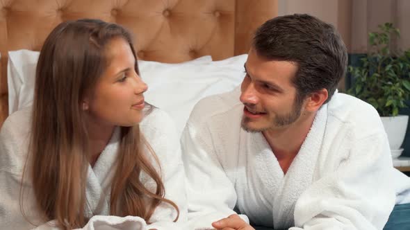 Happy Loving Couple Talking Lying in Bed Together Wearing Bathrobes 1080p