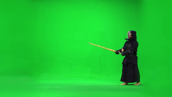 Masculine Kendo Warrior Practicing Martial Art with the Bamboo Bokken on Green Screen.