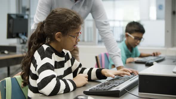 Darkhaired Girl Sitting and Typing on Keyboard