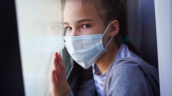 Teen Girl in Protective Mask Look Out of Window Outside