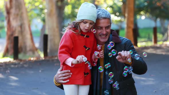 Father and daughter blowing bubbles