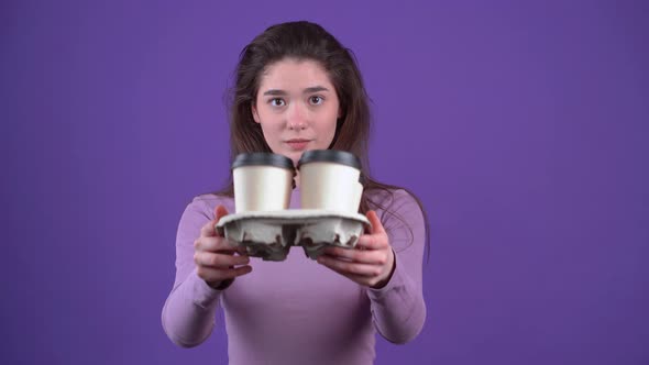 The Charismatic Young Woman Careful with Four Glasses of Coffee in Her Hand Stretches Them Displays