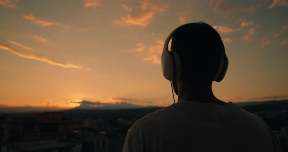 Silhouette of a boy with headphones at Sunset