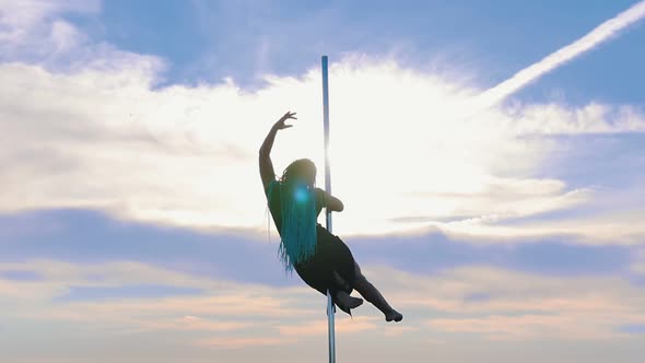 Pole Dance on Nature - Woman with Blue Braids Gracefully Dancing on the Background of Sky