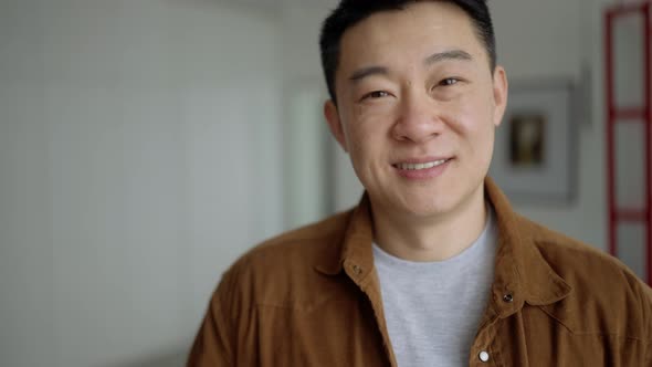 Smiling Asian man wearing casual cloth looking at the camera