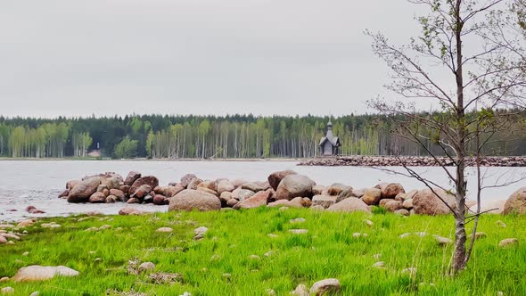 An Old Chapel Stands on a Stone Promontory on the Water in Leningrad Region Russia at Cloudy Weather