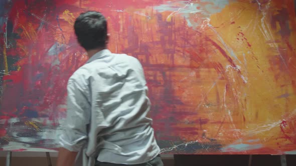 Male Artist Draws With His Hands On The Large Canvas, Using Hands Creates Colorful