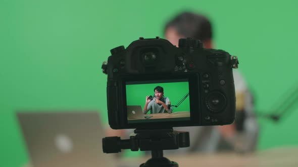 Close Up Of A Camera Monitor Recording Asian Man With Computer Reviewing Camera Len On Green Screen