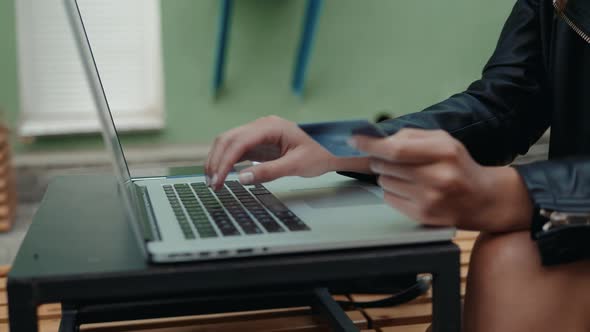 Young Woman Holding Credit Card and Using Laptop Computer