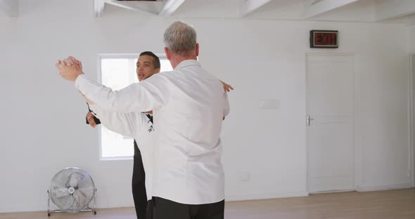 mixed race male dance teacher taking a ballroom dancing class at a dance studio