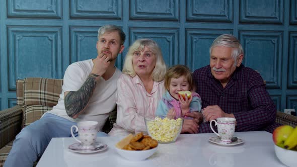 Multigenerational Family Getting Scared Watching Horror Television Movies Eating Popcorn at Home