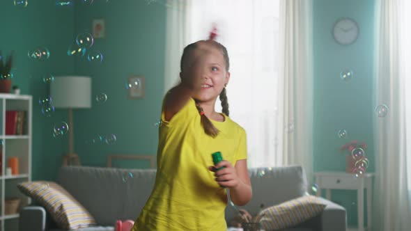 Happy Girl Is Playing with Soap Bubbles