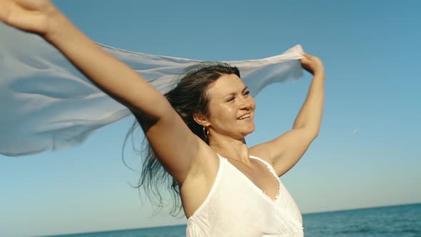 Beautiful Young Woman Girl Holding Pareo Fabric in the Wind Overlooking the Sea