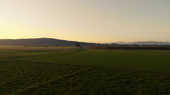 Aerial clip of the Bavarian flat land during sunrise, with a strong sun backlight.