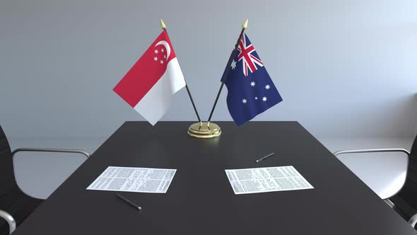Flags of Singapore and Australia and Papers on the Table