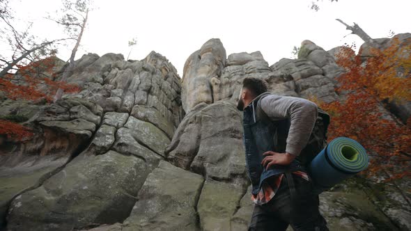 A Man is Standing at the Bottom of a Large Rock