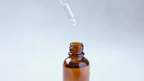 Essential Oil Dropping From Pipette to Bottle