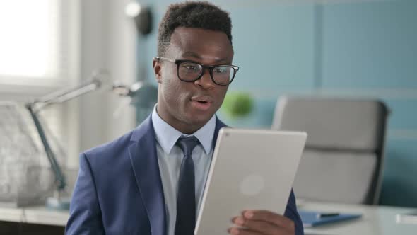 Portrait of Video Call on Tablet By African Man in Office