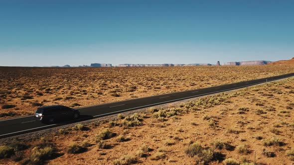 Beautiful Aerial Shot of Minivan Car Driving Along Amazing American Desert Highway Road