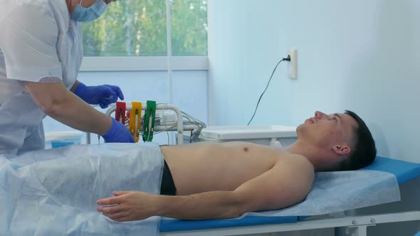 Nurse Preparing Male Patient for ECG Test