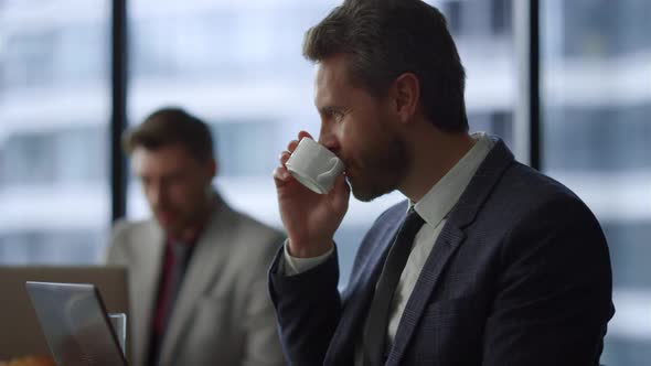 Successful Businessman Video Call on Laptop Drink Morning Coffee in Cafe Office