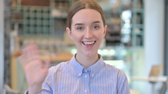 Portrait of Young Businesswoman Waving at the Camera 