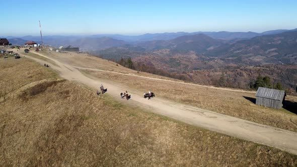 Aerial View People Riding Horse Attraction at the Top of Mountain