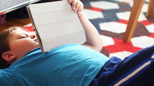 Boy using digital tablet in living room