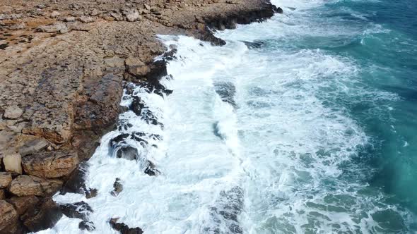 Rocky Coastline Cliffside with Blue Mediterranean Sea Ocean Water at Sunny Day Cyprus