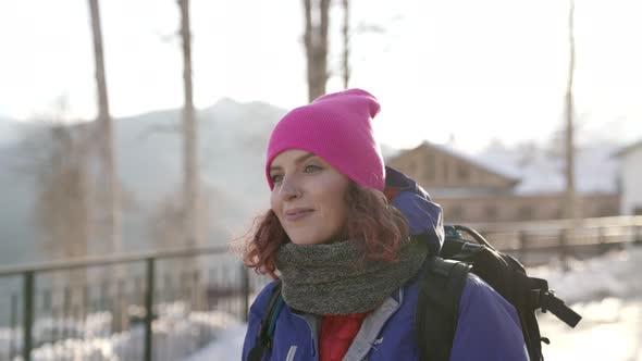 Skier Woman in Ski Resort City at Winter Day Walking on Street and Smiling To Camera