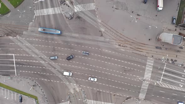 Tram and Cars Moves Through a Large Intersection - Drone Overhead Zoom-in Shot