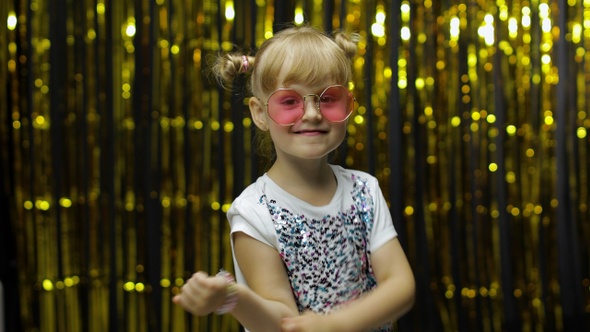 Child Kid Dancing, Celebrating Victory, Fooling Around. Girl Posing on Background with Foil Curtain