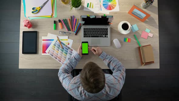 Young Designer Scrolling Phone With Green Screen, Using App for Finding Job